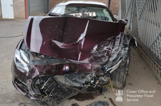 The front of a badly damaged red Maserati Quattroporte