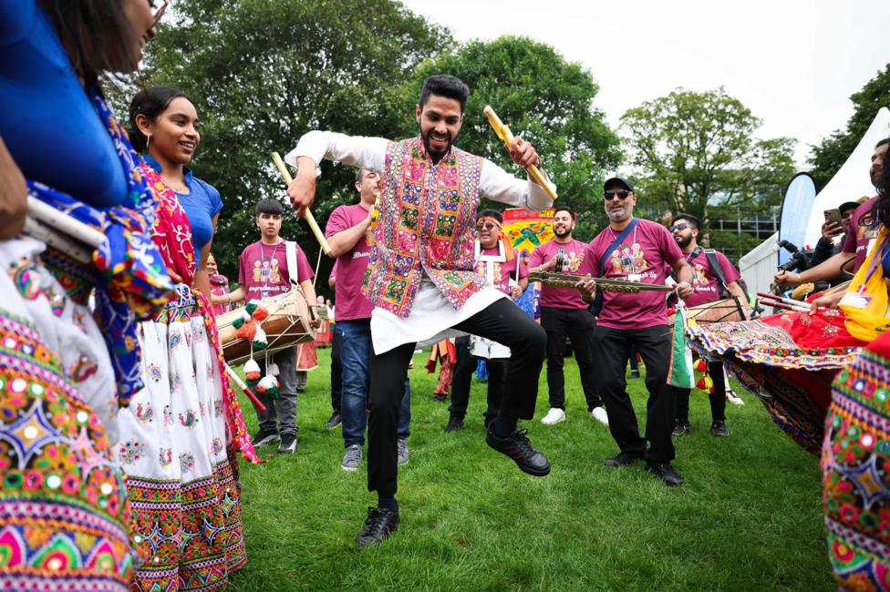 Men in pink outfits dancing