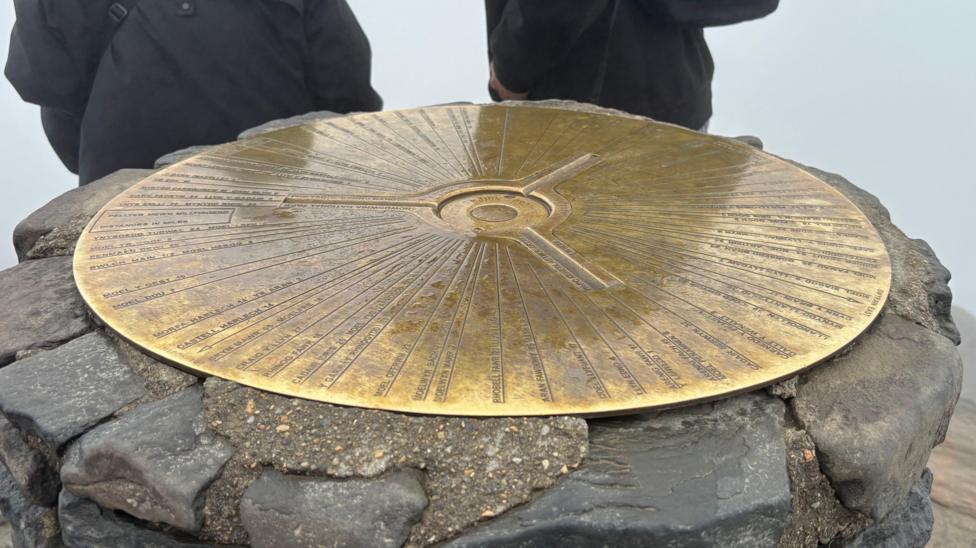The brass trig point plate which sits at the top of Yr Wyddfa on a stone platform
