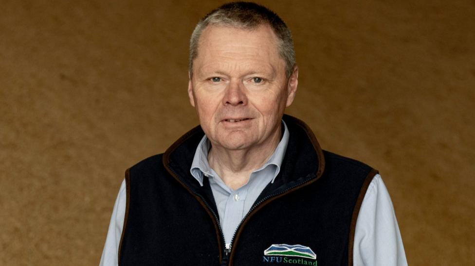 A man with short grey/blond hair in an NFU Scotland zip-up top with a shirt underneath