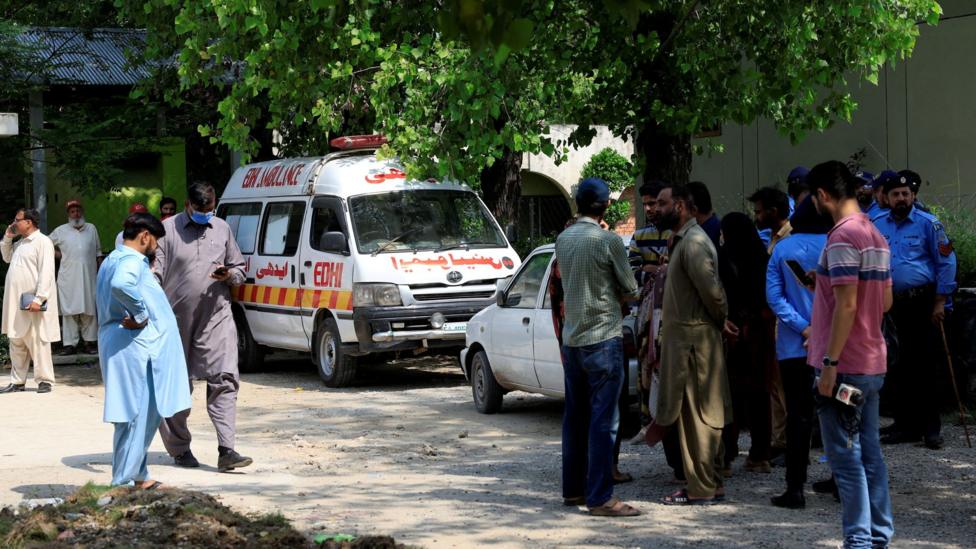 Family members and police officers stand outside a mortuary following a deadly fire at the Pakistan Institute of Medical Sciences (PIMS) hospital in Islamabad, Pakistan, August 26, 2026.