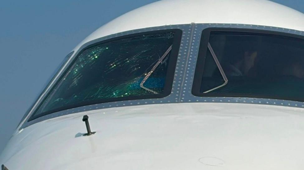 Imagine of an airplane window wit a large crack on the cockpit screen.