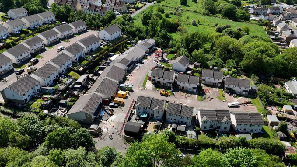 An aerial view of a number of residential streets with trees surrounding them
