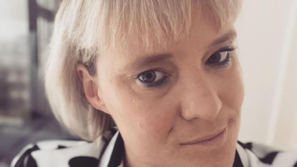 Dr Jessica Eccles, a woman with short blonde hair with a fringe, looks into the camera. She is wearing a black and white blazer. 