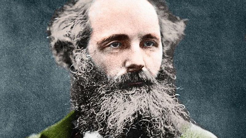 A painting of James Clerk Maxwell who has a very long beard and straggly black and grey hair. He is wearing what looks like a green jacket