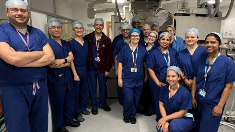 Doctors and nurses in dark blue outfits and light blue caps.