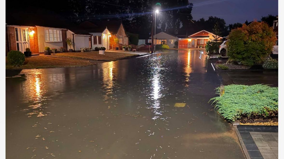 A cul-de-sac heavily flooded with water coming up to the front gardens of several houses.