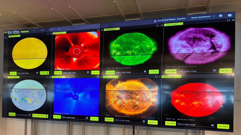 Eight LED screens in an office, with different coloured circles dominating each one. Colours range from yellow to purple. It's not possible to make out the detail of the text underneath