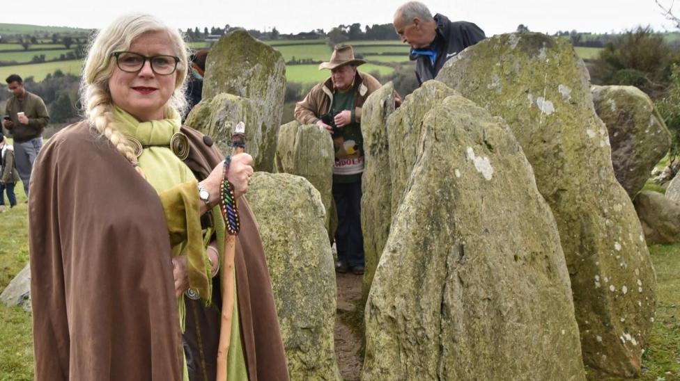 Eimear Burke in her druid robes among some standing stones