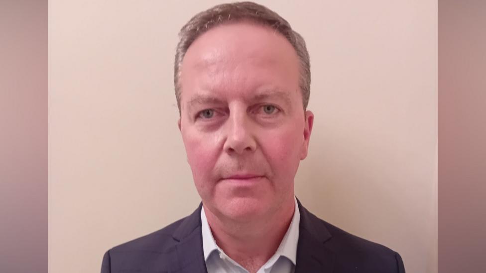 Gary Quinn is an older man with short fair hair that is greying at the sides