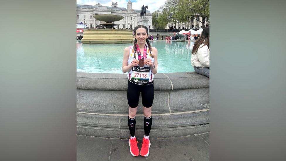 Lucy holding her London Marathon finisher medal