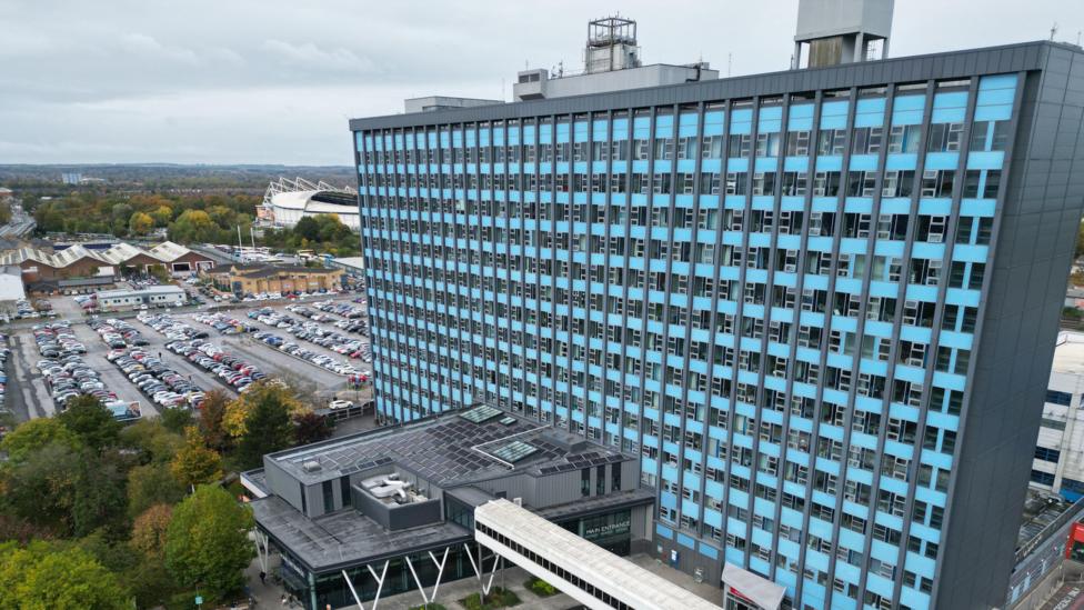 The Hull Royal Infirmary tower block is a 13-storey building with symmetrical rows of windows separated by blue panels of cladding.