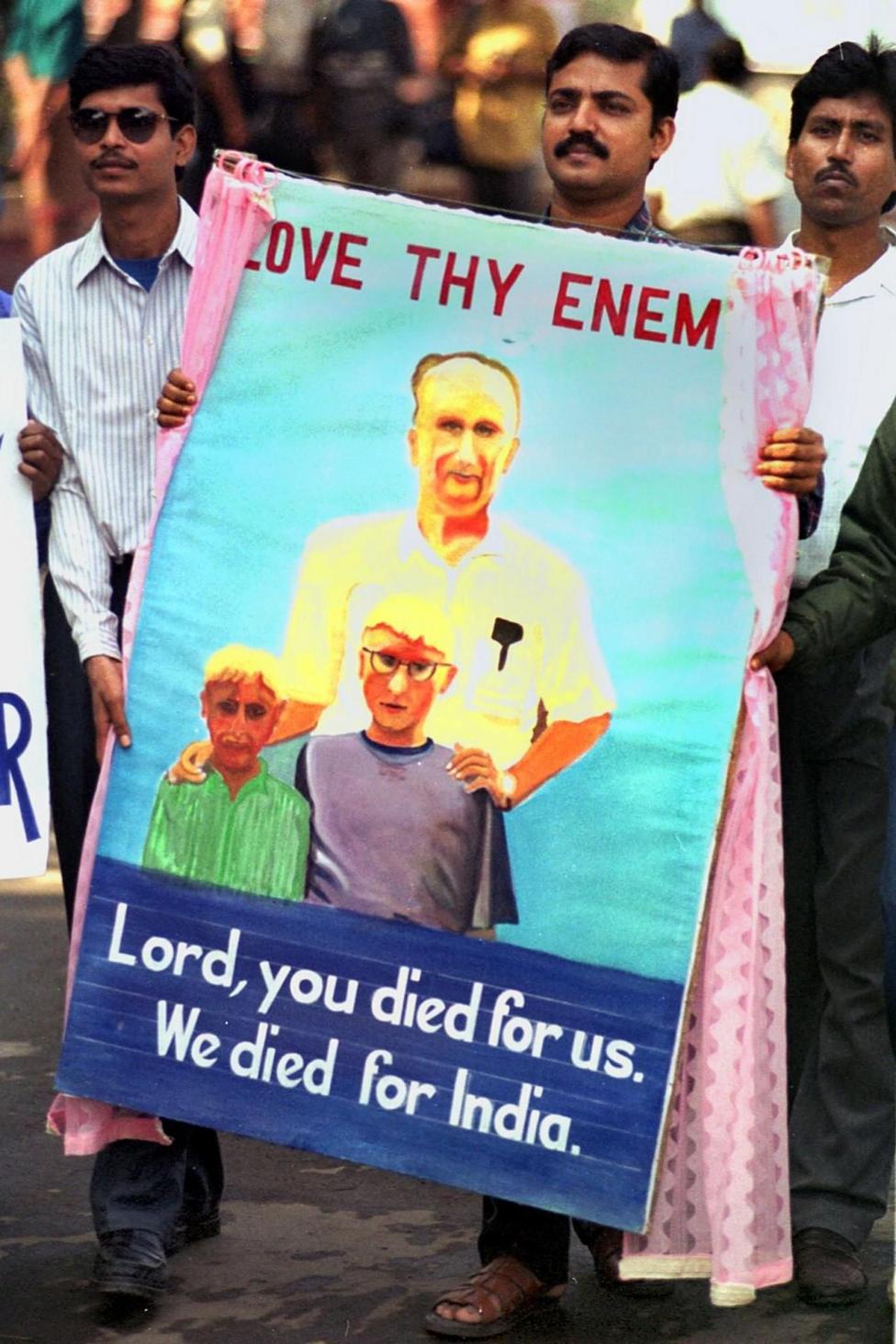 People carrying a portrait of Graham Staines, the Australian missionary who was murdered along with his two sons by Hindu fundamentalists last year, as a remembrance during a "millennium harmony march" to mark the 400th anniversary of the 'Bandel' church 23 November 1999 in Calcutta. AFP PHOTO (Photo by ARKO DATTA / AFP) (Photo by ARKO DATTA/AFP via )