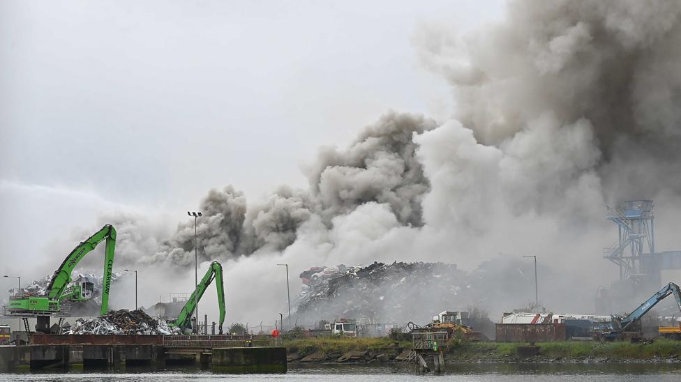 Large plumes of smoke over the shipyard.