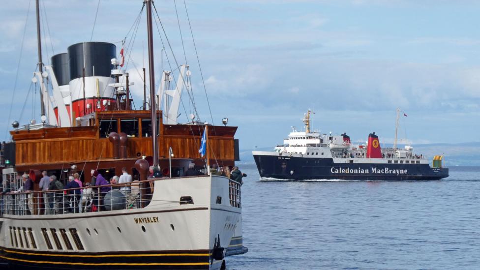 The Waverley paddlesteamer in the foreground with the ferry in the background. There are people on the deck of the Waverley and flags flying from the masts.