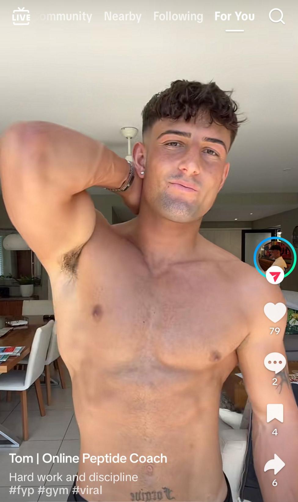 A screen grab from Tom's Tiktok live - it shows him posing in the middle of the frame with his right arm up to show his upper torso, he is not wearing a top and is bare chested