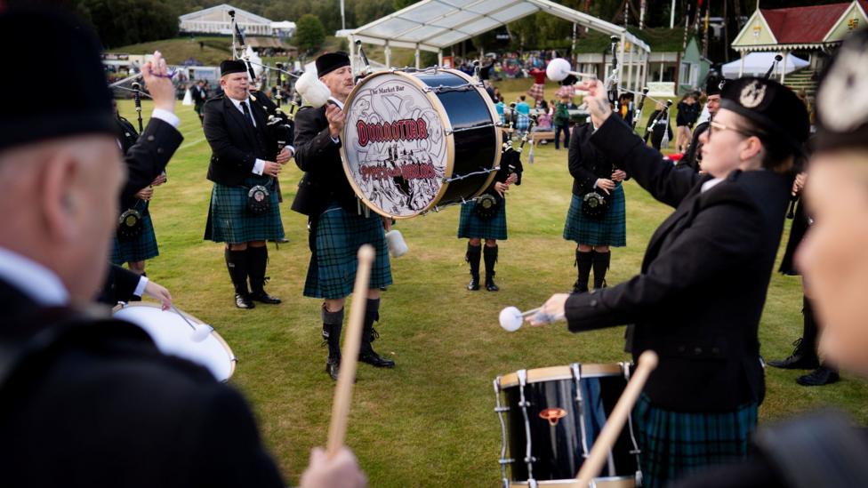 two band members playing drums as part of a pipe band