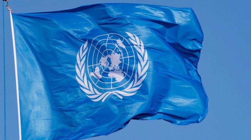 Flag of the United Nations waves in the wind on a flagpole. The emblem on the flag is coloured white depicting the world map in the azimuthal equidistant projection which is surrounded by a pair of olive branches. File photo