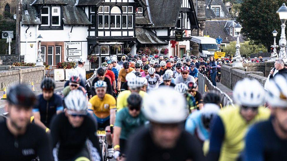 Hundreds of cyclists packed together on the roads of the Borders