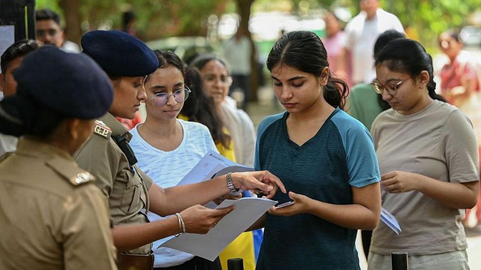 Police personnel check documents of medical students before National Eligibility-cum-Entrance Test (NEET-UG) re-examination in Ahmedabad on June 21, 2026.
