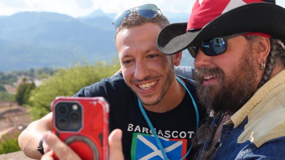 A man in a BargaScot T-Shirt and another in a hat with a Canada flag on it take a selfie together