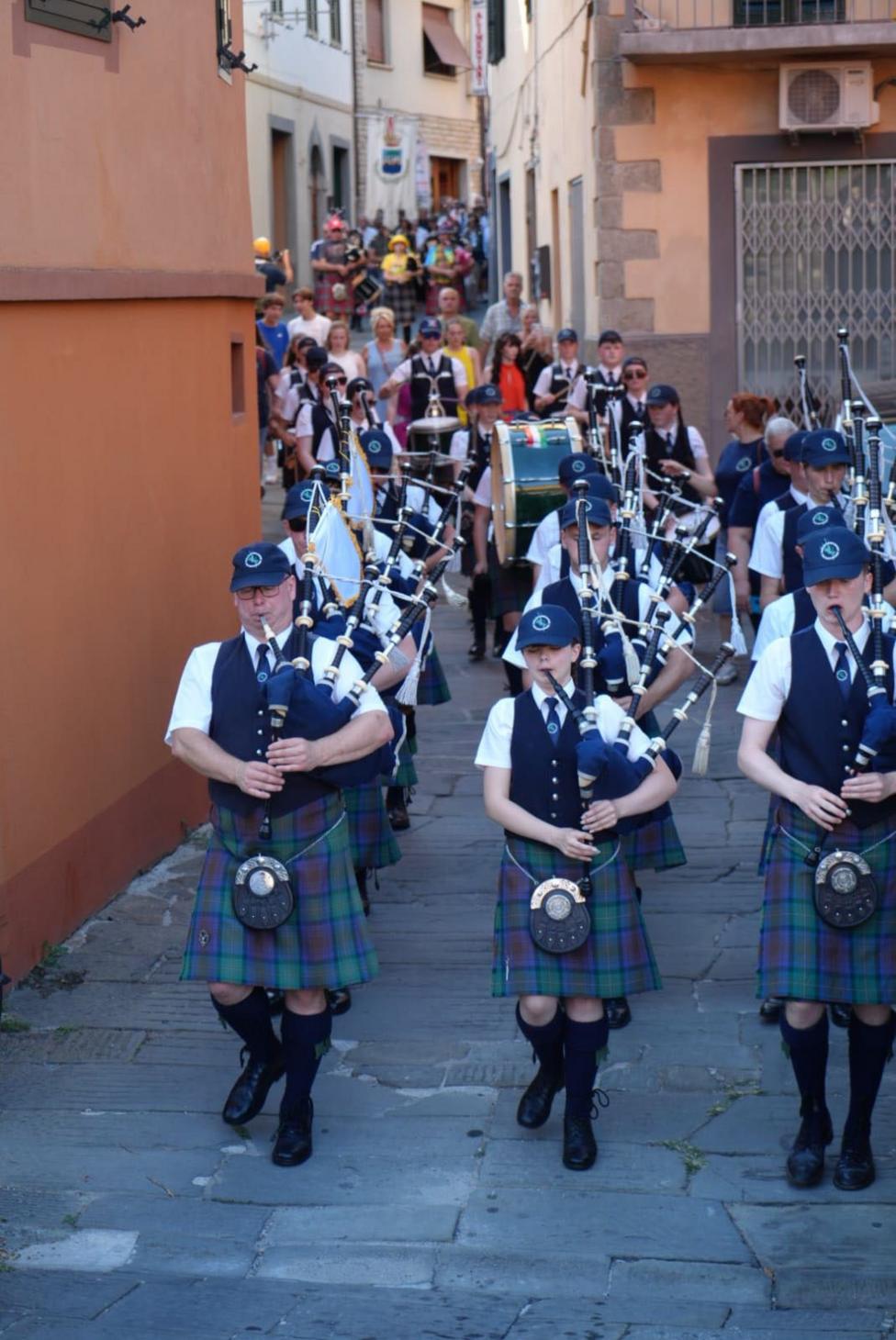 A pipe band makes its way along a typical Tuscan street