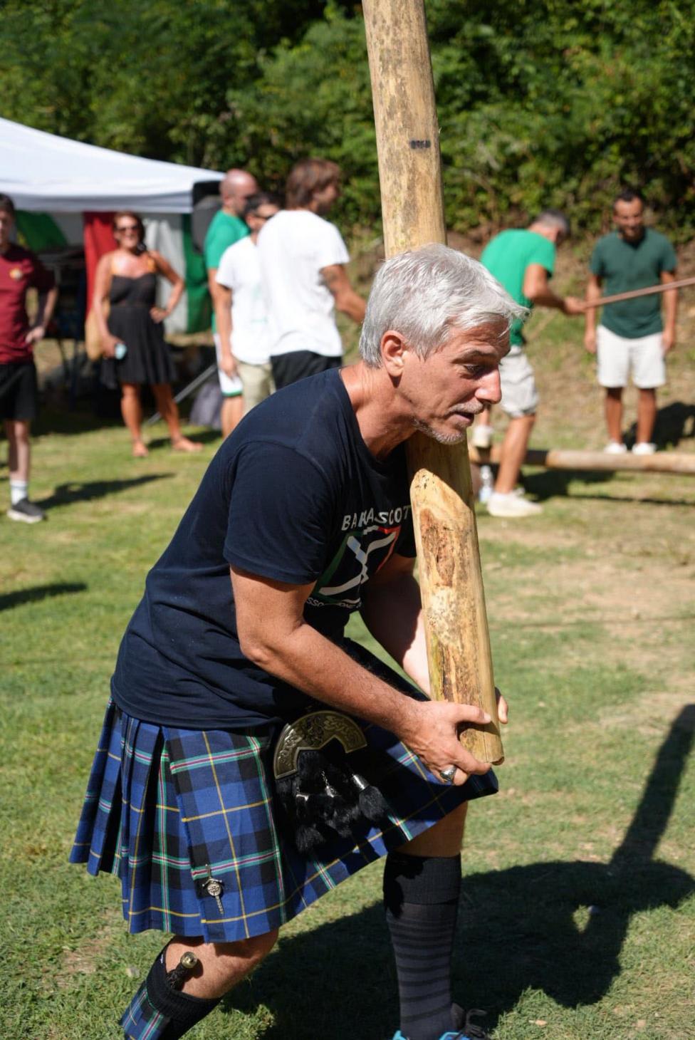 A man in a kilt tosses a caber