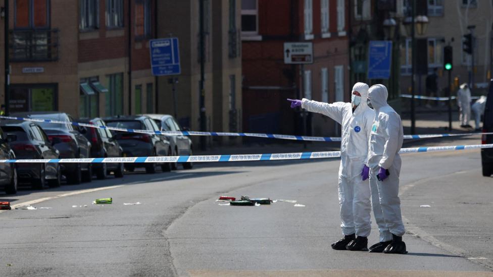 A cordon in Nottingham after attacks in the city carried out by valdo calocane. Two forensic officers stand in the middle of the road inside a police cordon.