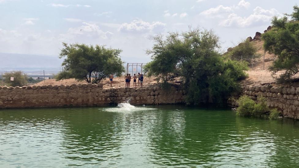 Israeli settlers stand beside Herod's Pool, which they have set up as a swimming pool this summer with water diverted from a Palestinian village, in the Jordan Valley, in the occupied West Bank