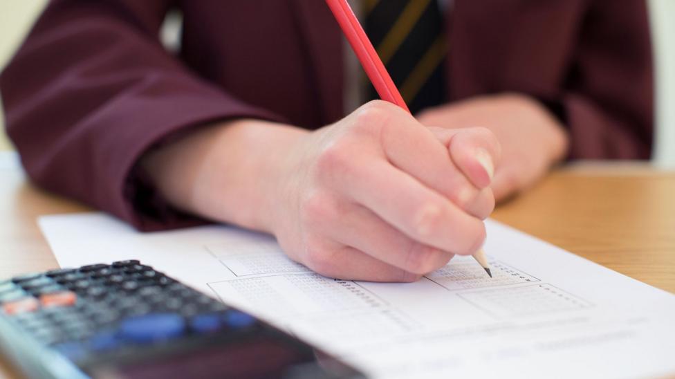 Close Up Of Female Pupil In Uniform Taking Multiple Choice Examination Paper.