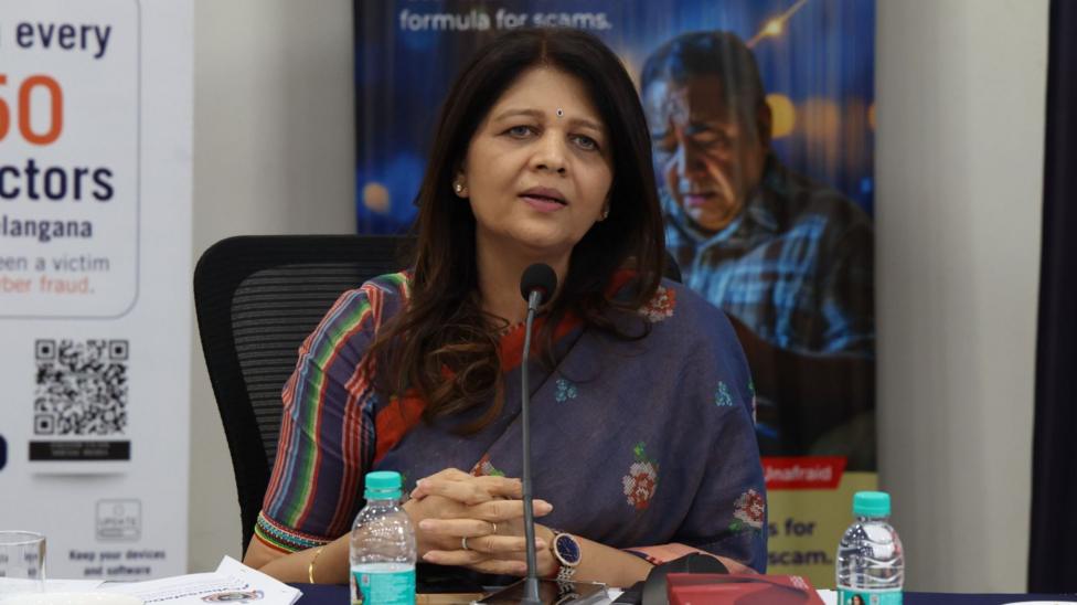 Shikha Goel, a cyber police officer from India's Telangana state, speaks into a mic while sitting at a desk