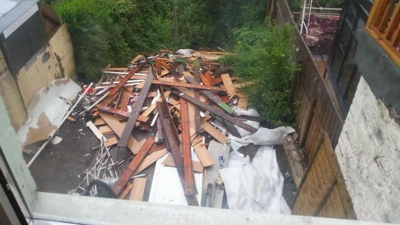 Piles of wood panels and other household materials removed from the home during building work. The waste was left by Lee Slocombe outside the home, following incomplete renovation work.