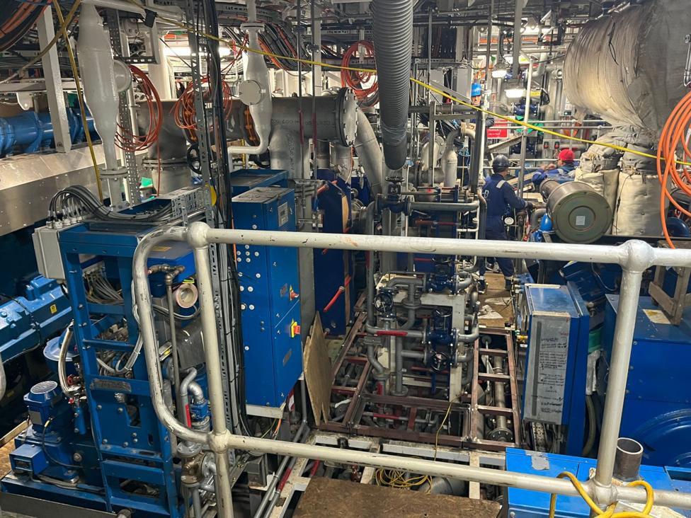 A machinery space on a ship with lots of densely packed pipework