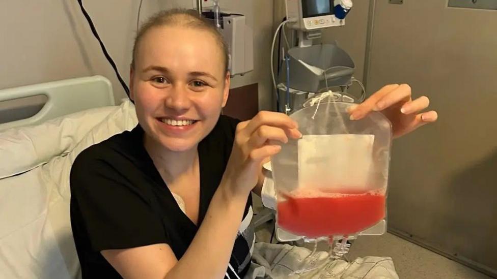 Faith Hinitt holding a bag of stem cells from an anonymous donor