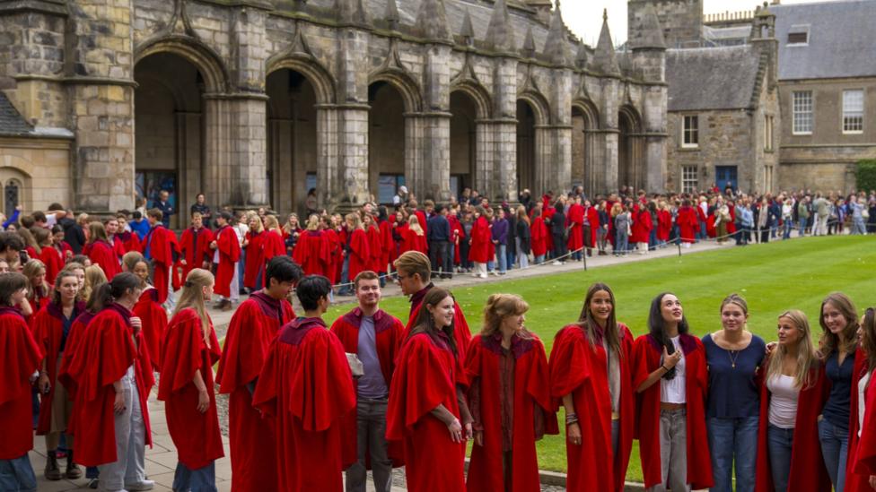 Undergraduates at the University of St Andrews, wearing their distinctive red academic gowns, in St Salvator's Quad before taking part in the traditional Pier Walk along the harbour walls of St Andrews before the start of the new academic year