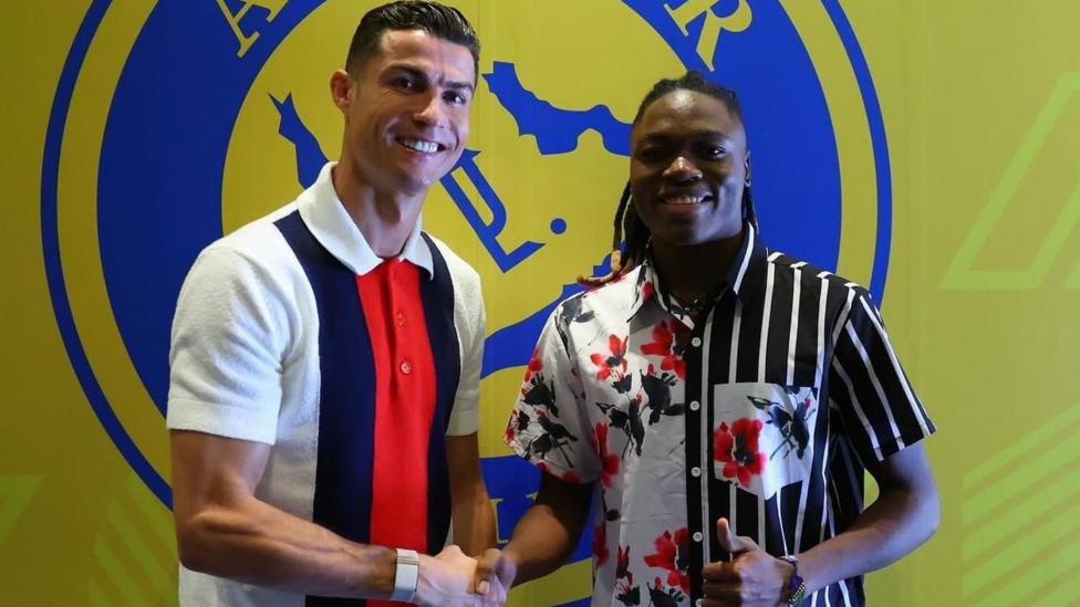 Tanzanian striker Clara Luvanga shakes hands with Portuguese star Cristiano Ronaldo in front of a banner showing the club crest of Saudi club Al-Nassr