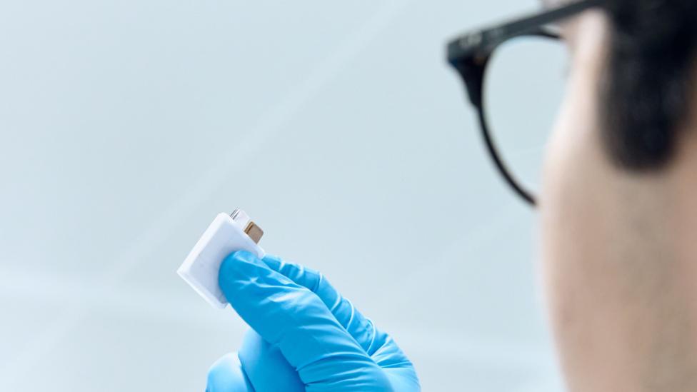 A LeydenJar worker holds up a battery that uses the company's nano-coating