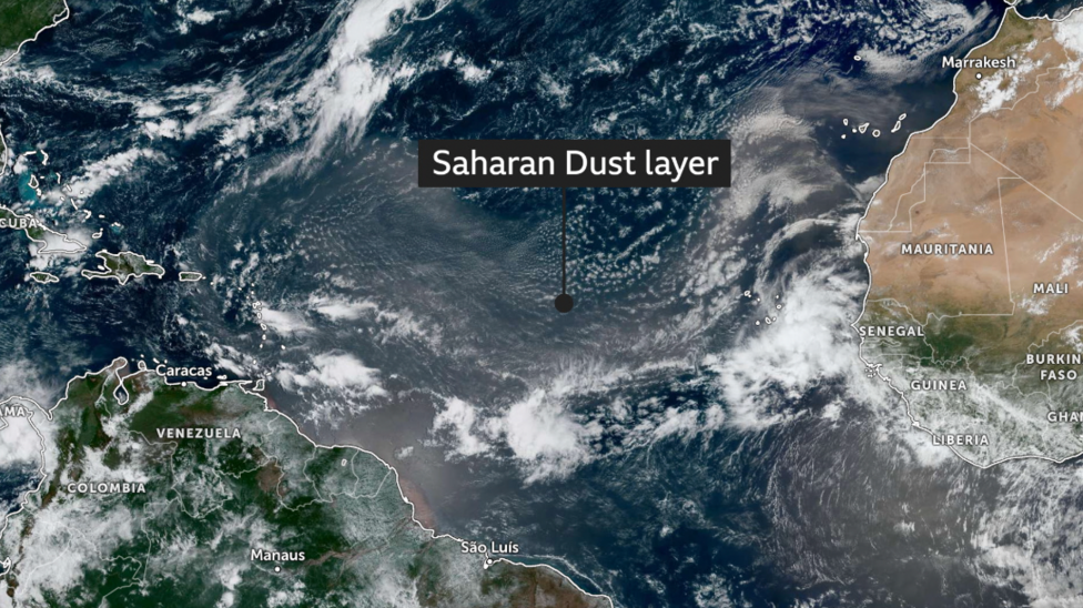 satellite imagery over the Atlantic Ocean, showing some areas of cloud but also a large area of brown haze which is a large area of dust from the Sahara suspended in the air