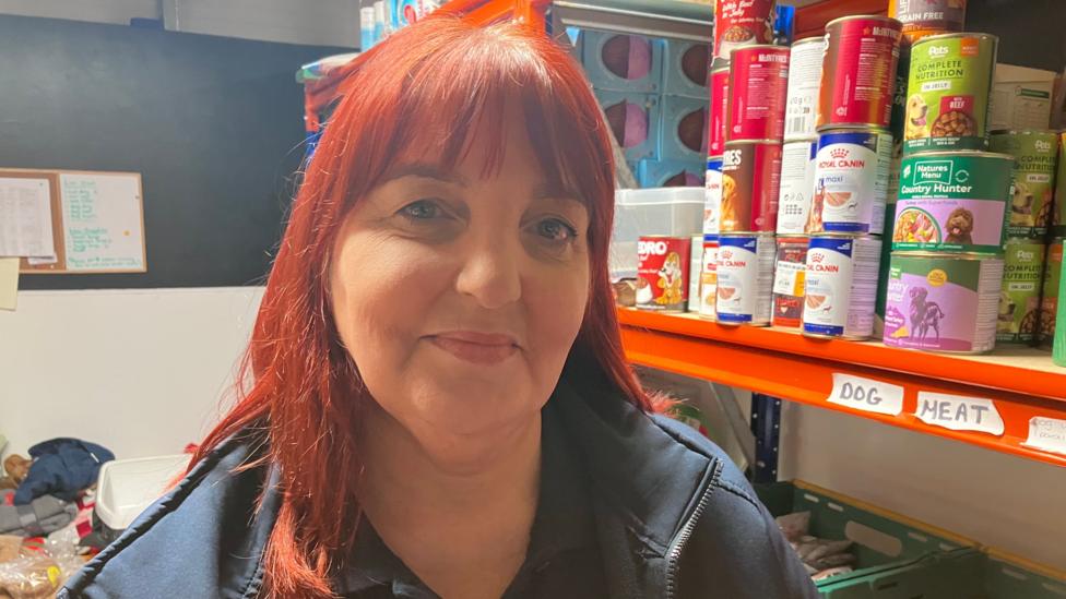 A woman with red hair smiles at the camera