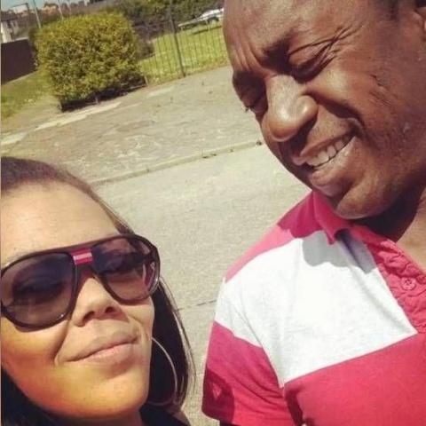 A selfie of Natalie (left) and her dad Anthony (right). She is wearing sunglasses and has dark hair with some of it pulled back. Anthony is looking at his daughter and smiling, he has an earring and is wearing a red and white striped shirt. 