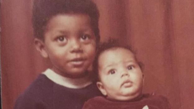 Natalie (right) as a baby with her older brother Leroy (left) just behind her. They both have brown eyes and brown hair. 