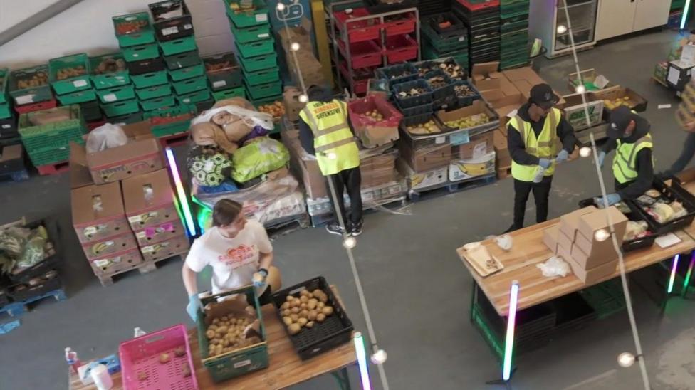 An aerial view of four people working in a food distribution warehouse.
