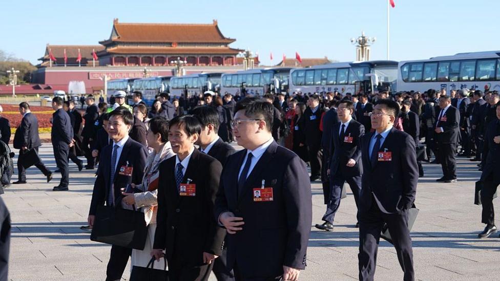 Men in suits and red badges walking in Beijing