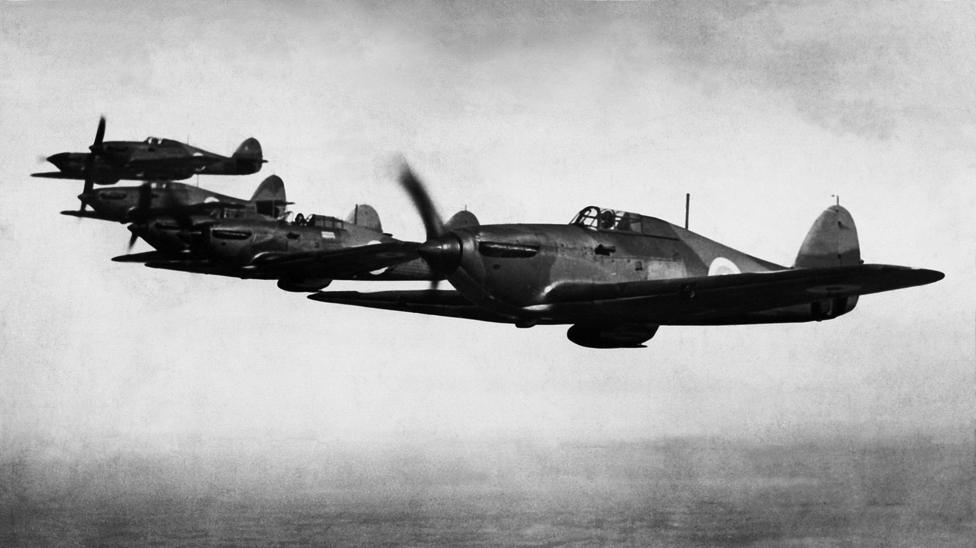 Six RAF early Hawker Hurricane MK1 fighter aircraft with two blade fixed pitch propellers in flight over England. circa August 1938. 