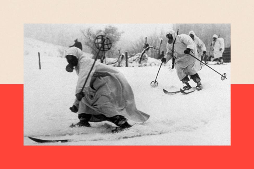 Finnish troops wearing gas masks and white robes skiing across the countryside