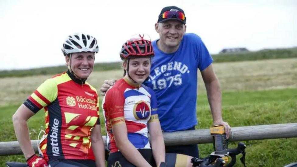 Zoe Backstedt on a bike with her mother Megan (left) and father Magnus right