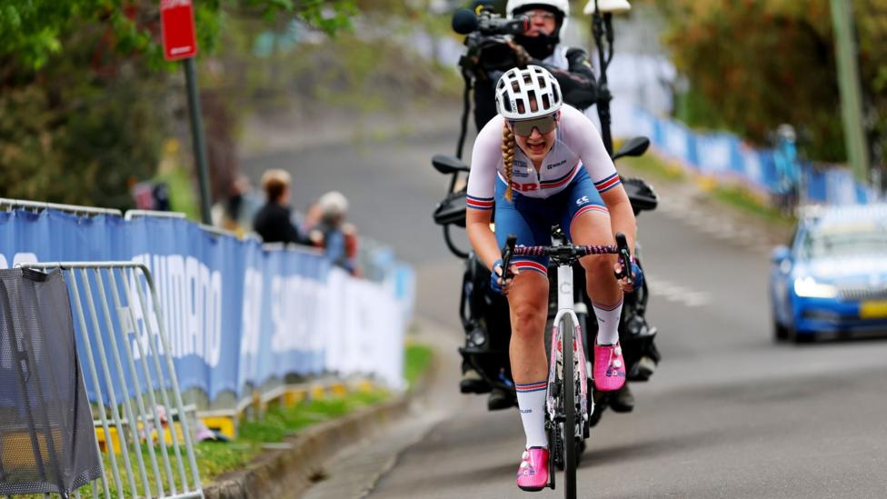 Zoe Backstedt rides up an incline followed by a motorbike camerman