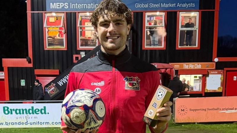 Alex Hardwick poses with a matchball