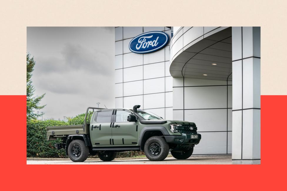 A variant of Ford's Ranger, built for military duty, sits outside the entrance to Ford's Dangenham plant underneath the company's logo.