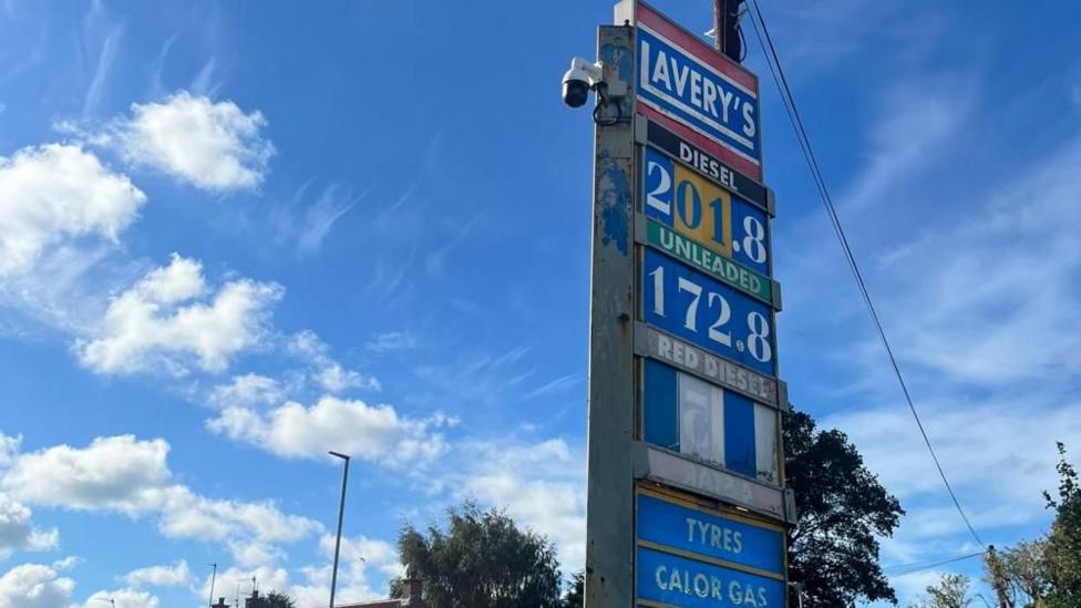 A petrol pump sign that reads 201.8 for diesel and 172.8 for petrol. The sign is old and a bit rusty. It is mostly blue in colour.